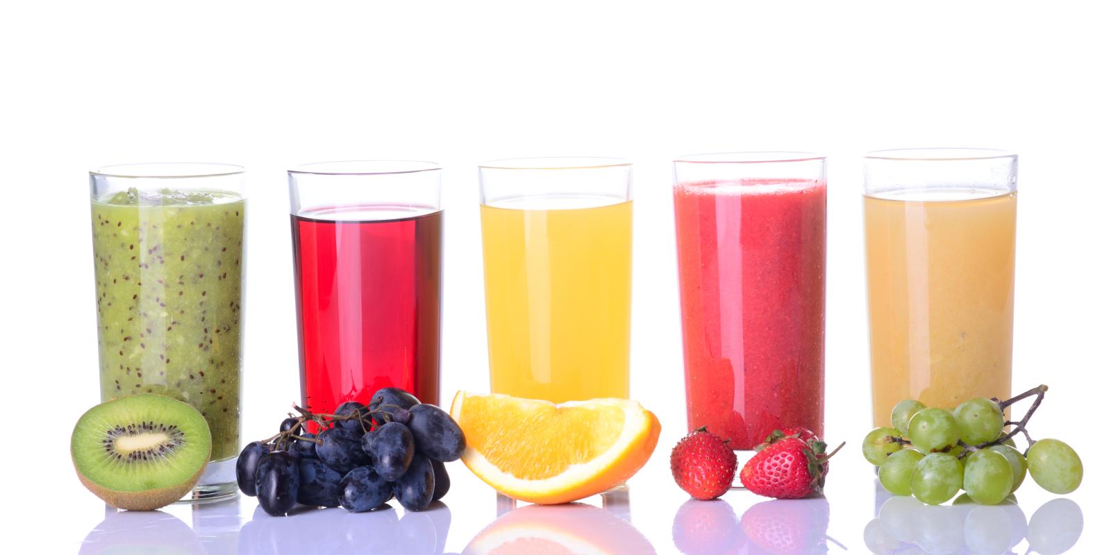 Bilde av fem glass med jus og frukt: Fra venstre kiwi, blå druer, appelsin, jordbær og grønne druer.