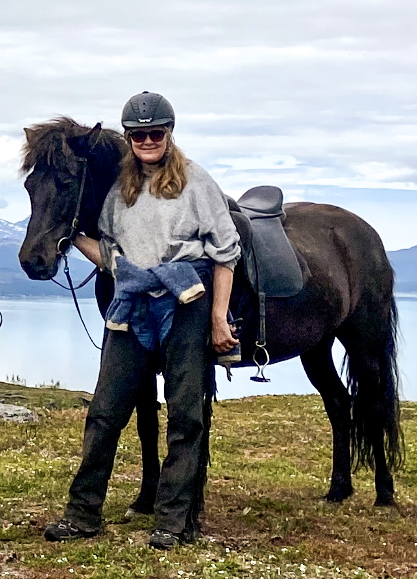 Bilde av forsker Agnete Kristoffersen som står sammen med en hest. 