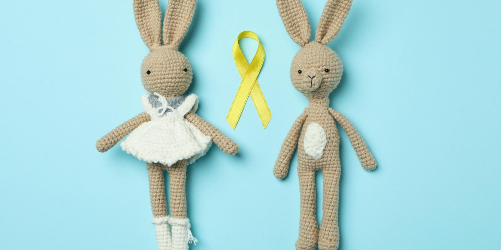 To kaninbamser med en gul sløyfe mellom seg.