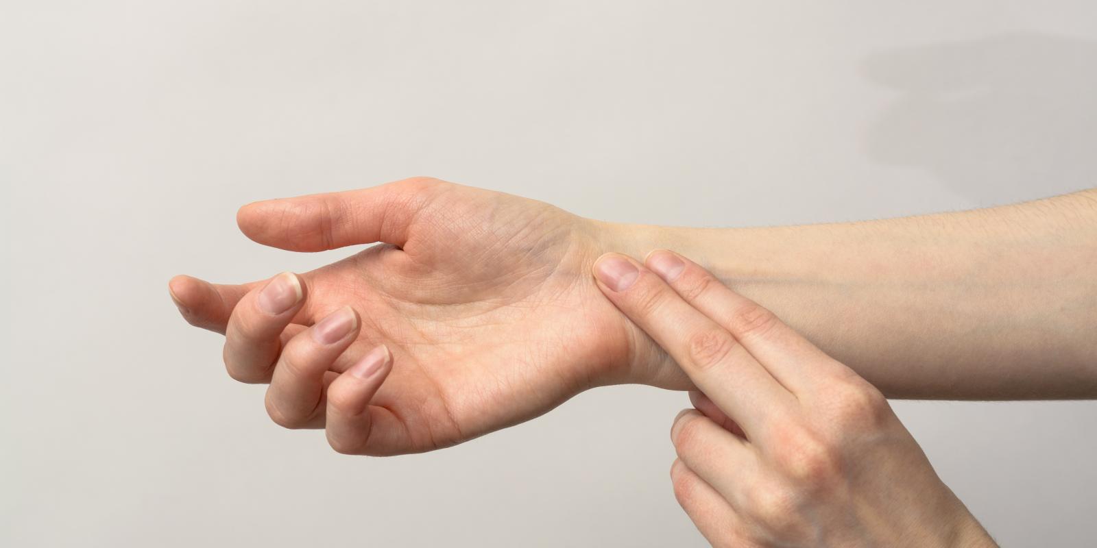 Bilde av en person som legger to fingre på et håndleddet