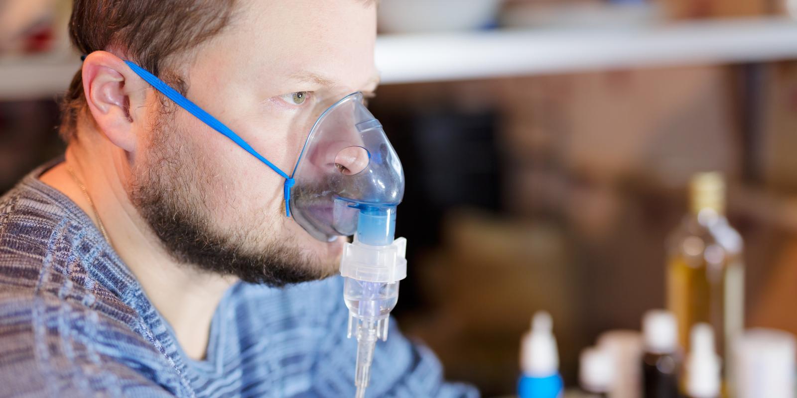 Bilde av hvit mann med inhalasjonsmaske over nese og munn