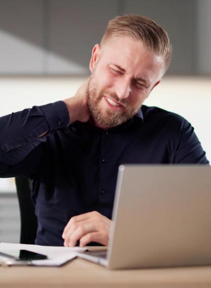Mann bak laptop på skrivebord