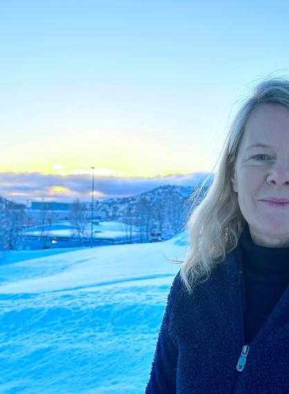 NAFKAMs leder Miek Jong står og smiler, ute foran solen, på campus ved UiT i Tromsø.