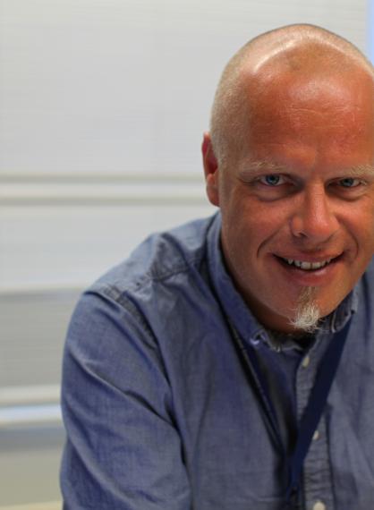 Ola Lillenes, informasjonssjef ved NAFKAM, smilende i mellomblå skjorte.